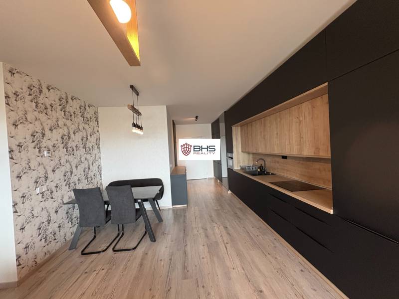 Kuchyňa v 2-izbovom byte s podlahou s dreveným dekorom a jedálenským kútom.