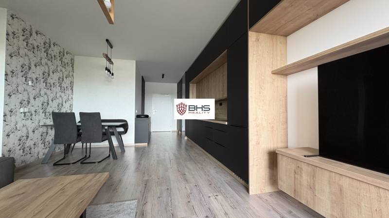 Jedáleň spojená s obývačkou a kuchyňou, podlaha s dreveným dekorom, 2-izbový byt.